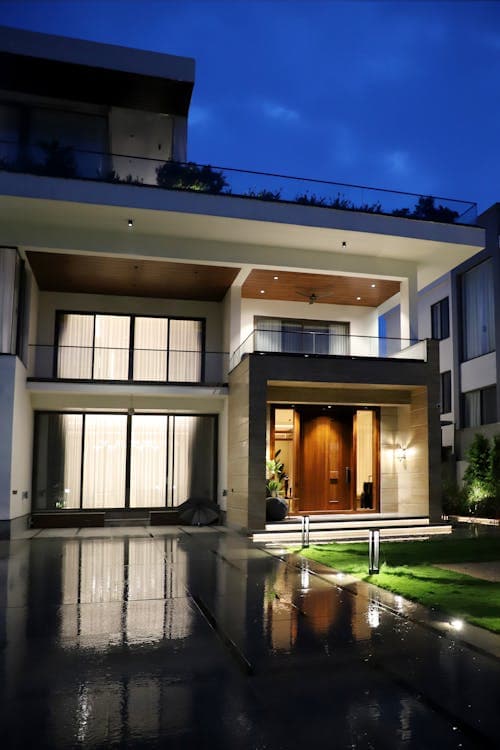 Modern new construction home at dusk with warm permanent LED roofline lighting illuminating the exterior facade in a Sacramento-area community