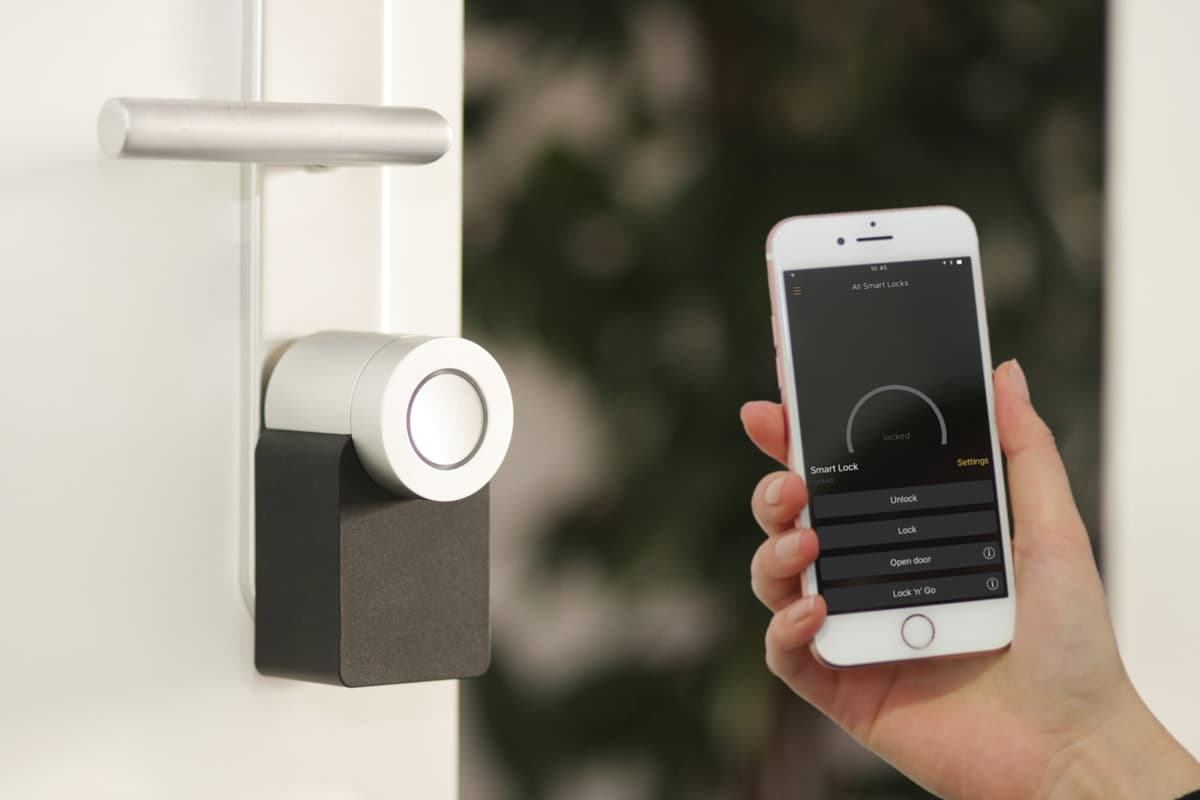 Homeowner using a smartphone app to dim and schedule energy-efficient permanent outdoor lights