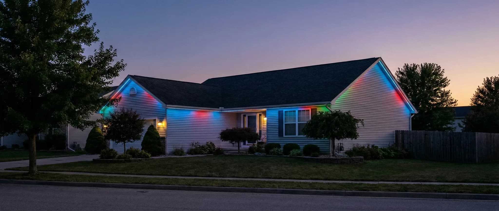 Ranch home with rainbow multicolor eave and landscape lighting